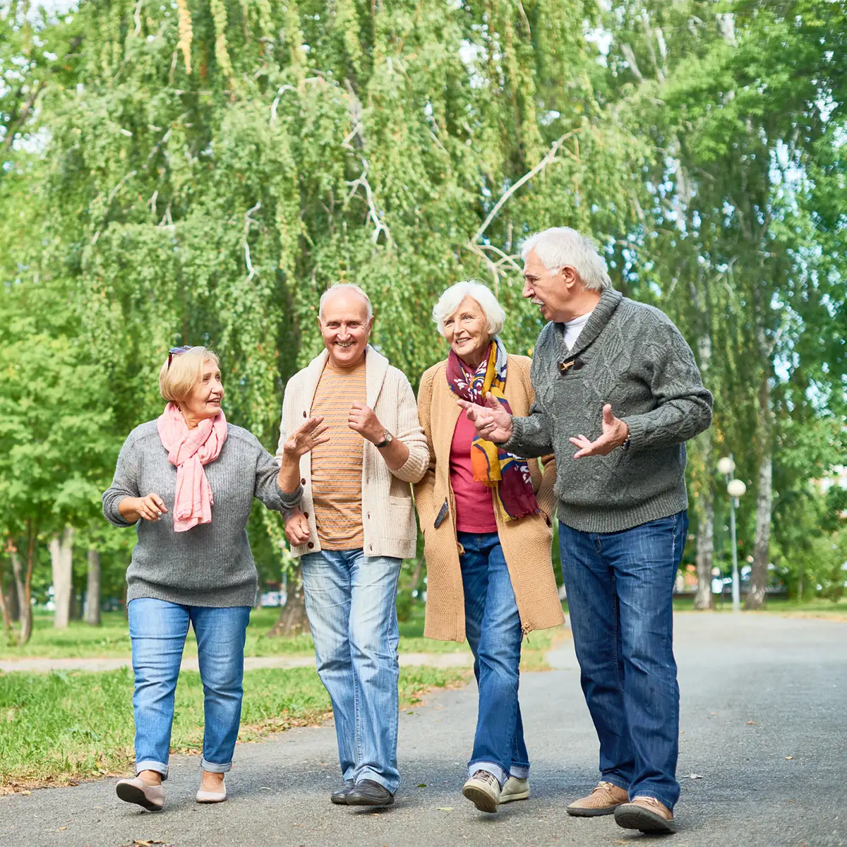Older adults, smiling and walking together, with other people in the background. Older adults, smiling and walking together, with other people in the background.